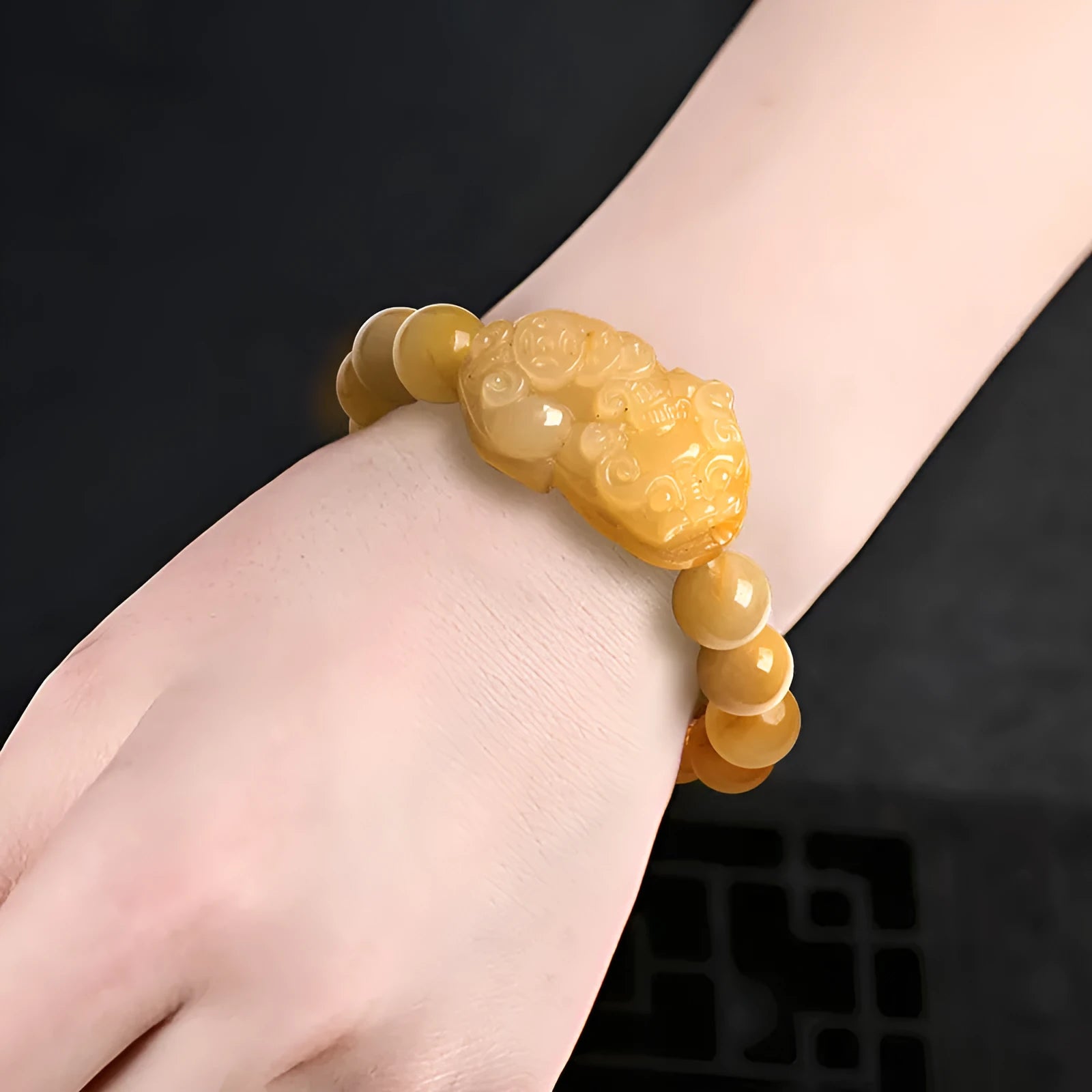 Carved golden thread jade money bracelet showing detail, available in large and small sizes with unisex design.