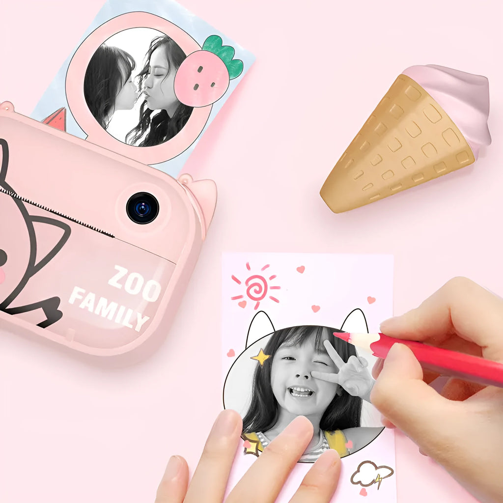 Pink instant print digital camera with 2.4-inch screen shown with printing paper and lanyard