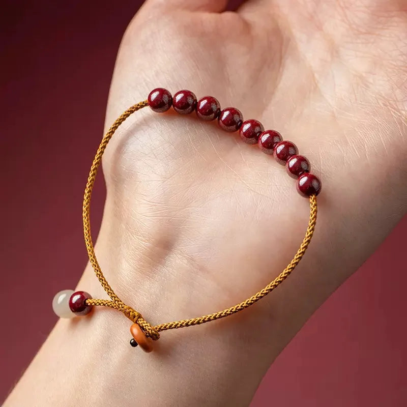 Hand-woven cinnabar and Hetian jade bracelet with geometric design showing natural colour variation