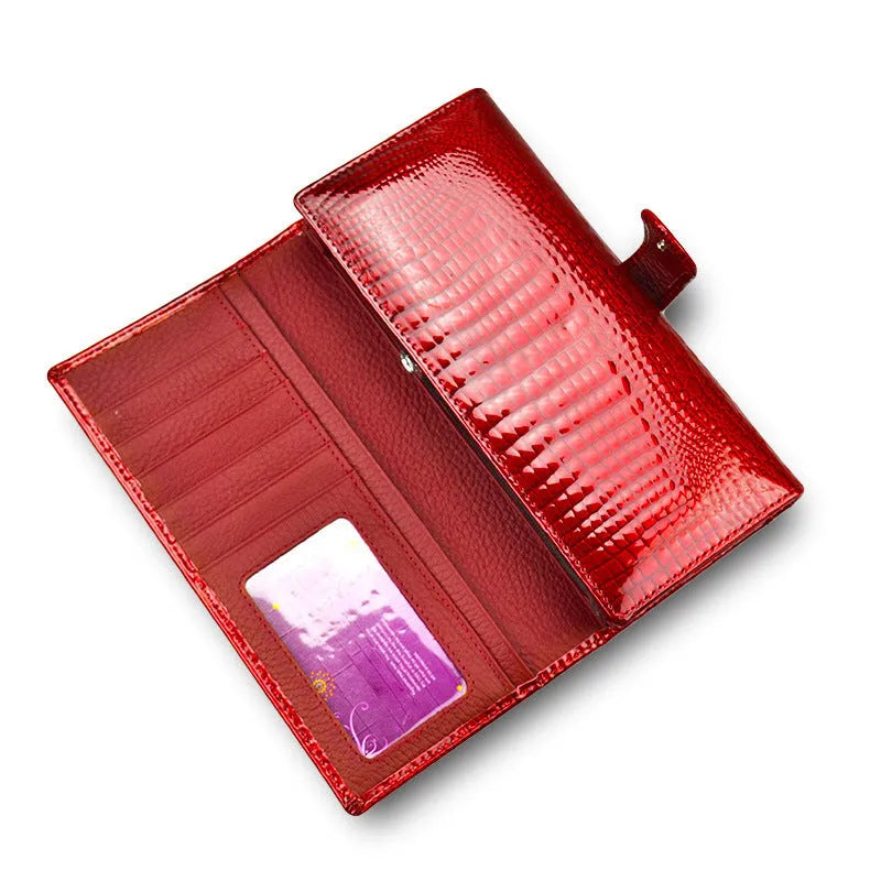 Women's patent leather purse with crocodile pattern in red colour showing pigskin lining interior