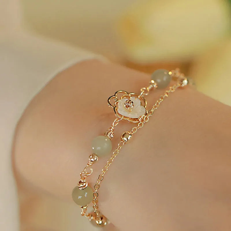 Yellow gold electroplated copper bracelet with genuine Hetian jade Bells of Ireland butterfly charm for women.
