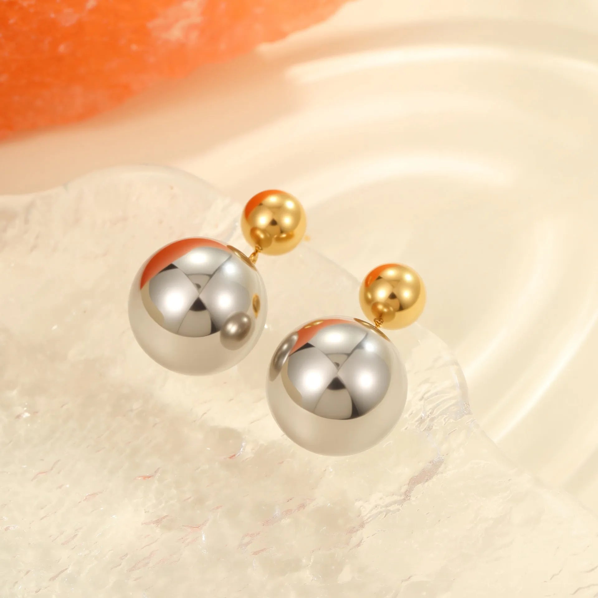 Stainless steel geometric ear studs with round beads and colour-block electroplated finish.