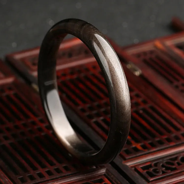 Natural silver stone cat's eye bracelet with geometric ethnic design on wrist.