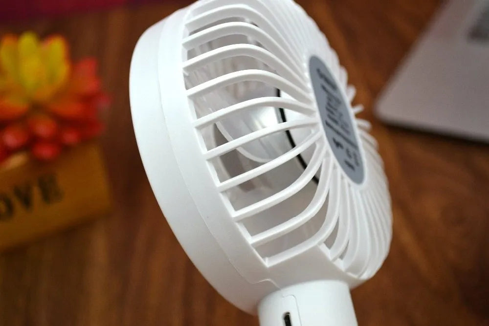 White ORICO FH1 portable USB desktop fan with rechargeable battery on a table.