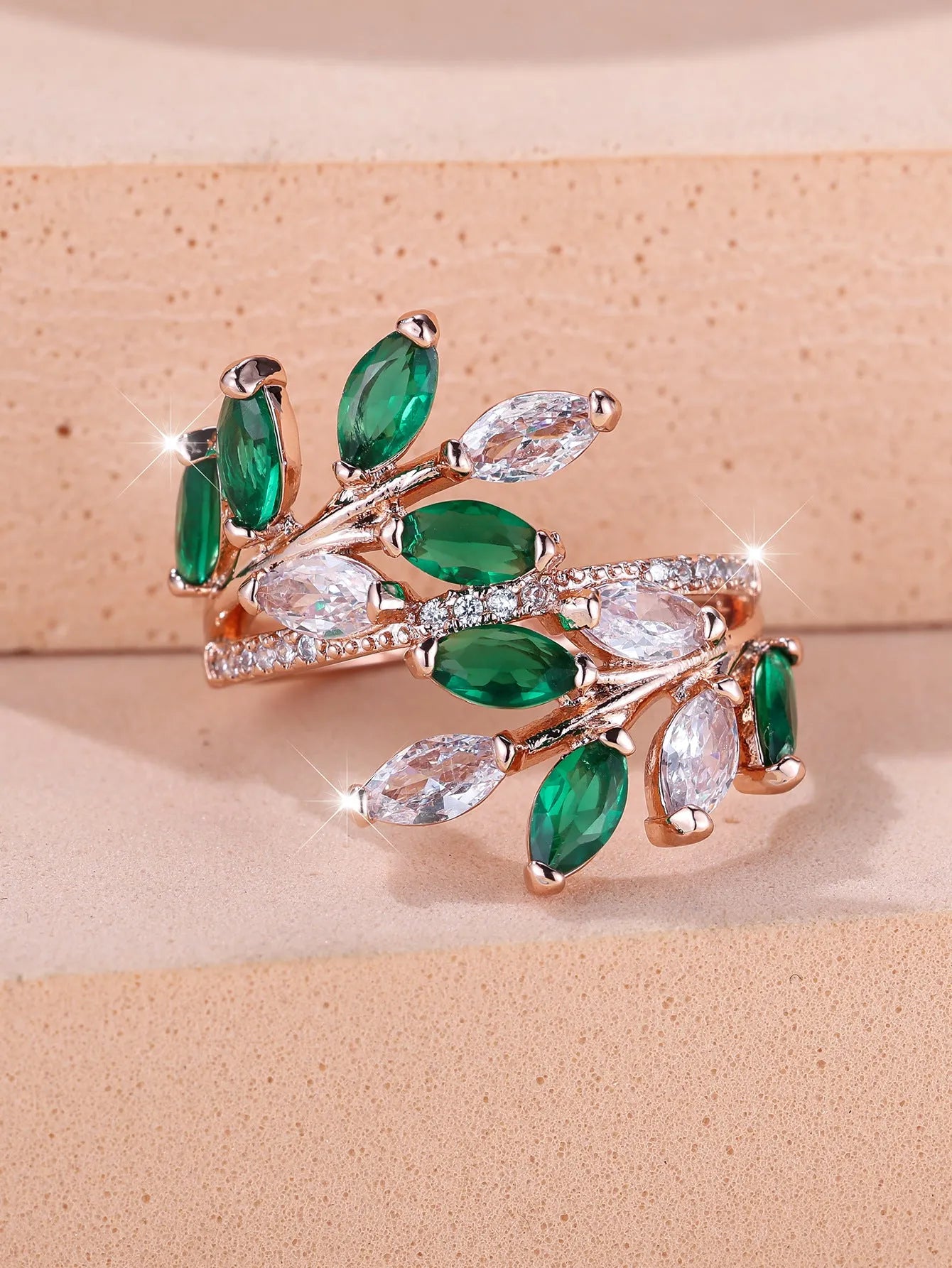 Adjustable copper leaf ring in platinum or rose gold finish on a white background