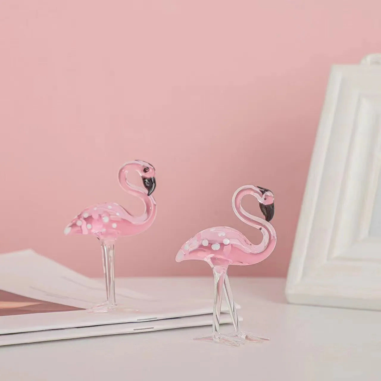Pink crystal flamingo decorative ornament on a table, modern minimalist style.