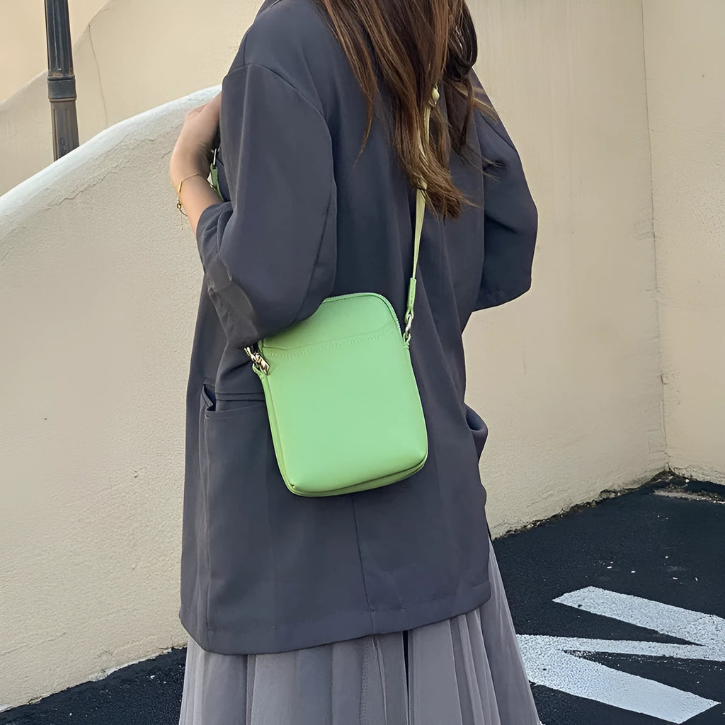 Women's solid colour PU crossbody shoulder bag showing compact dimensions and adjustable strap