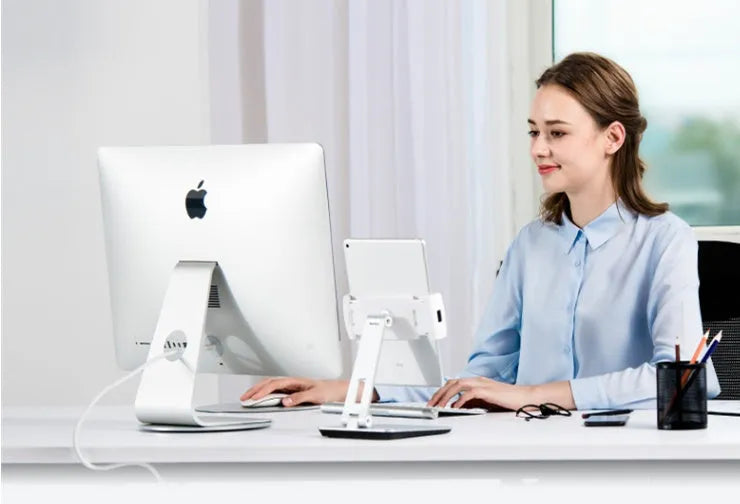 Black folding aluminium desktop stand holding a tablet at an angle, showing 360° rotation and silicone grips.