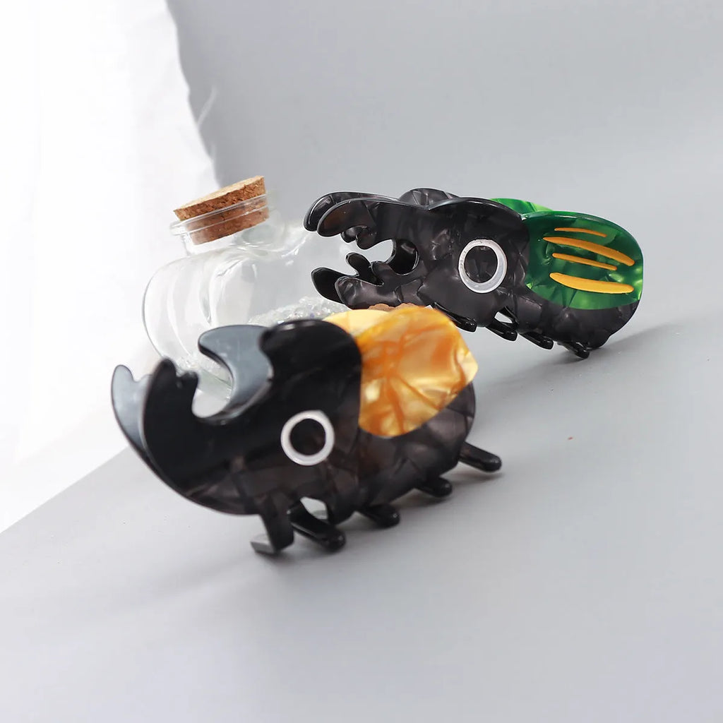 Handmade cartoon insect biology grip on cellulose acetate sheet in green beetle, orange beetle, or white caterpillar design.