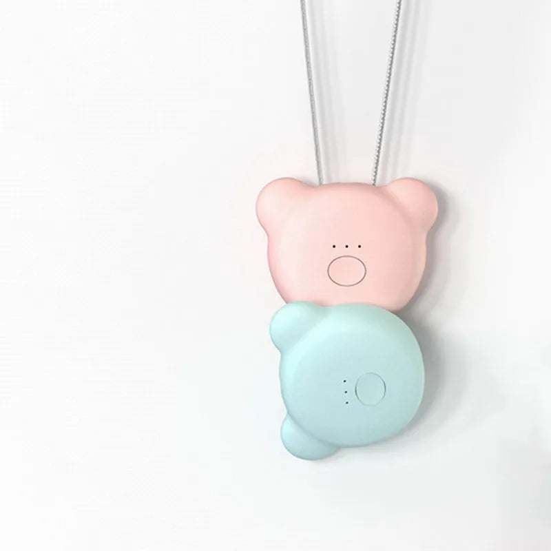 Small pink wearable USB air purifier necklace on a person, showing compact size.