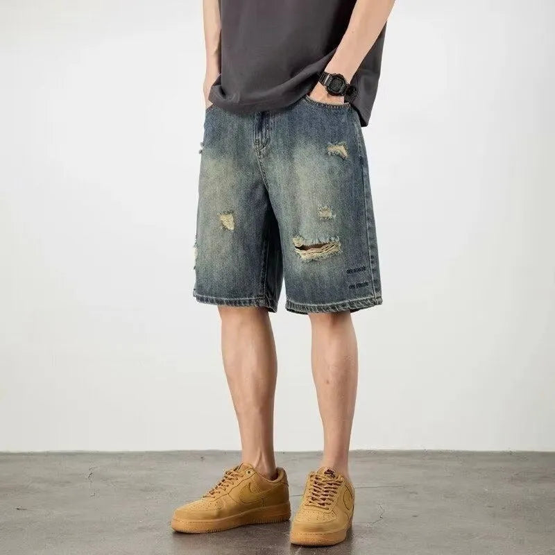 Men's blue retro loose hole denim shorts with a straight leg cut on a neutral background.