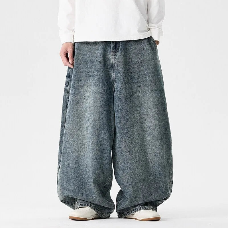 Man wearing light blue plus-size wide-leg casual denim jeans with a baggy fit and straight leg opening.