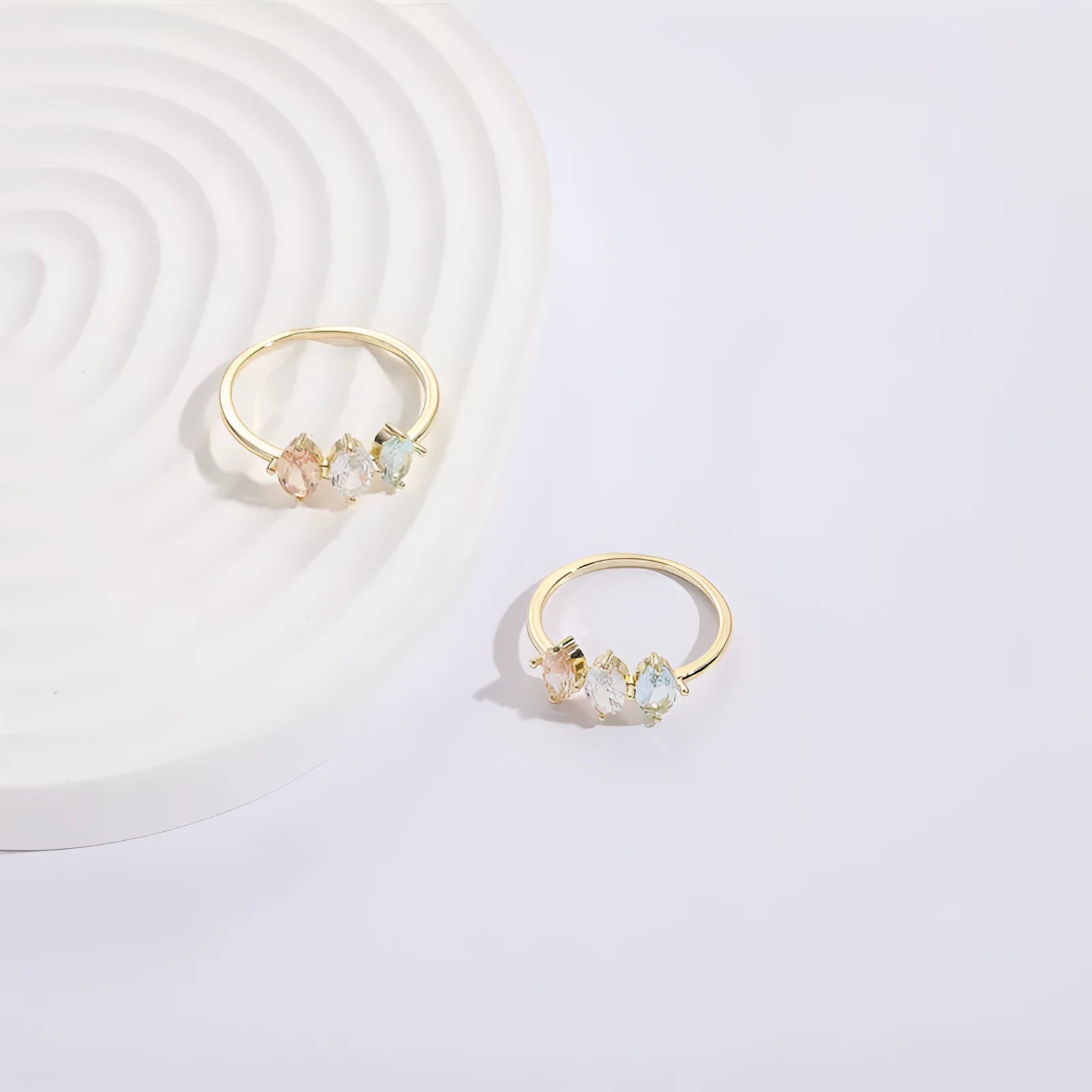 Women's gold-coloured ring with a horse eye design and three coloured zircon stones on a geometric band.
