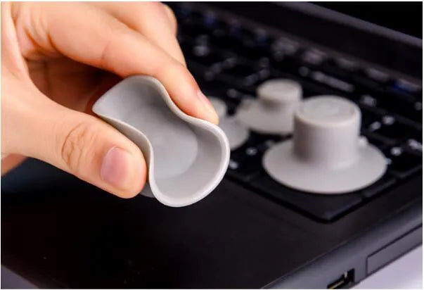 Grey plastic laptop cooling stand with four non-slip pads on a flat surface
