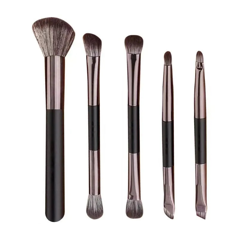 Makeup brush set with mirror open, showing silver and gold eyeshadow brushes inside a compact case.