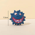 Set of four coloured squeaky dog balls with cute faces on a bumpy latex rubber surface.