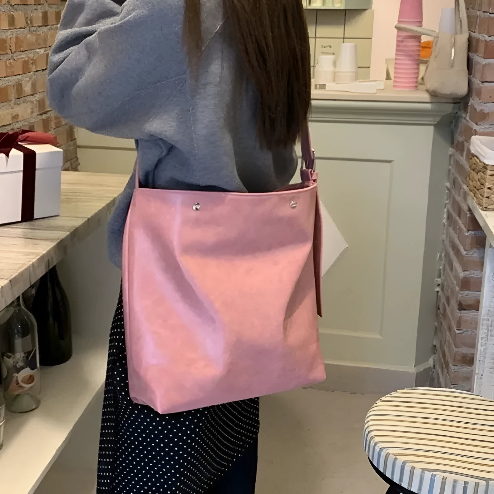 Pink corduroy one-shoulder bag with a single strap, shown next to a brown colour option.