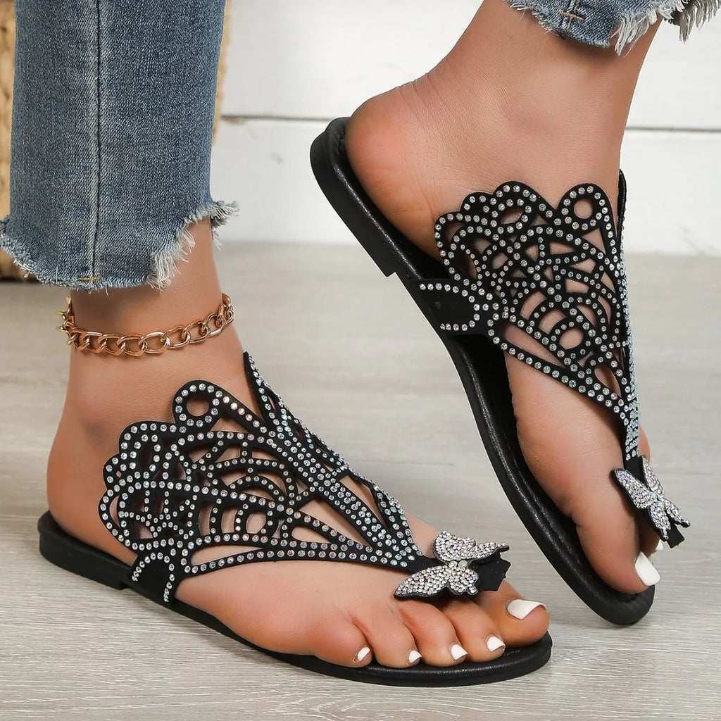 Women's black slip-on sandals with rhinestone details on flip-toe hollow design.