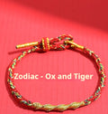 Adjustable eight-strand woven hand strap in multiple zodiac-inspired colours, showing the sliding length adjuster.