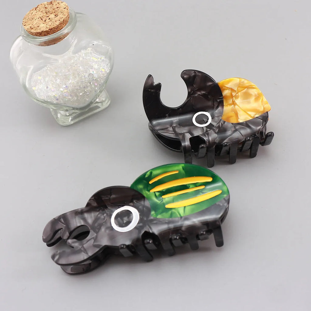 Handmade cartoon insect biology grip on cellulose acetate sheet in green beetle, orange beetle, or white caterpillar design.