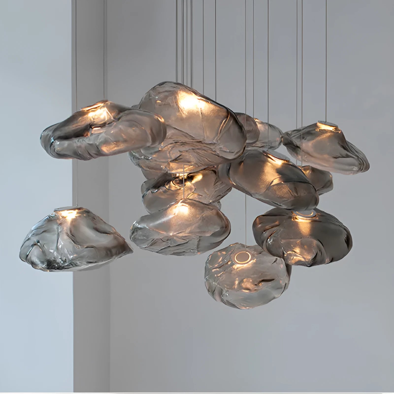 Modern fabric chandelier light with glass shade in amber, clear, or smoke grey, shown in small and large sizes.