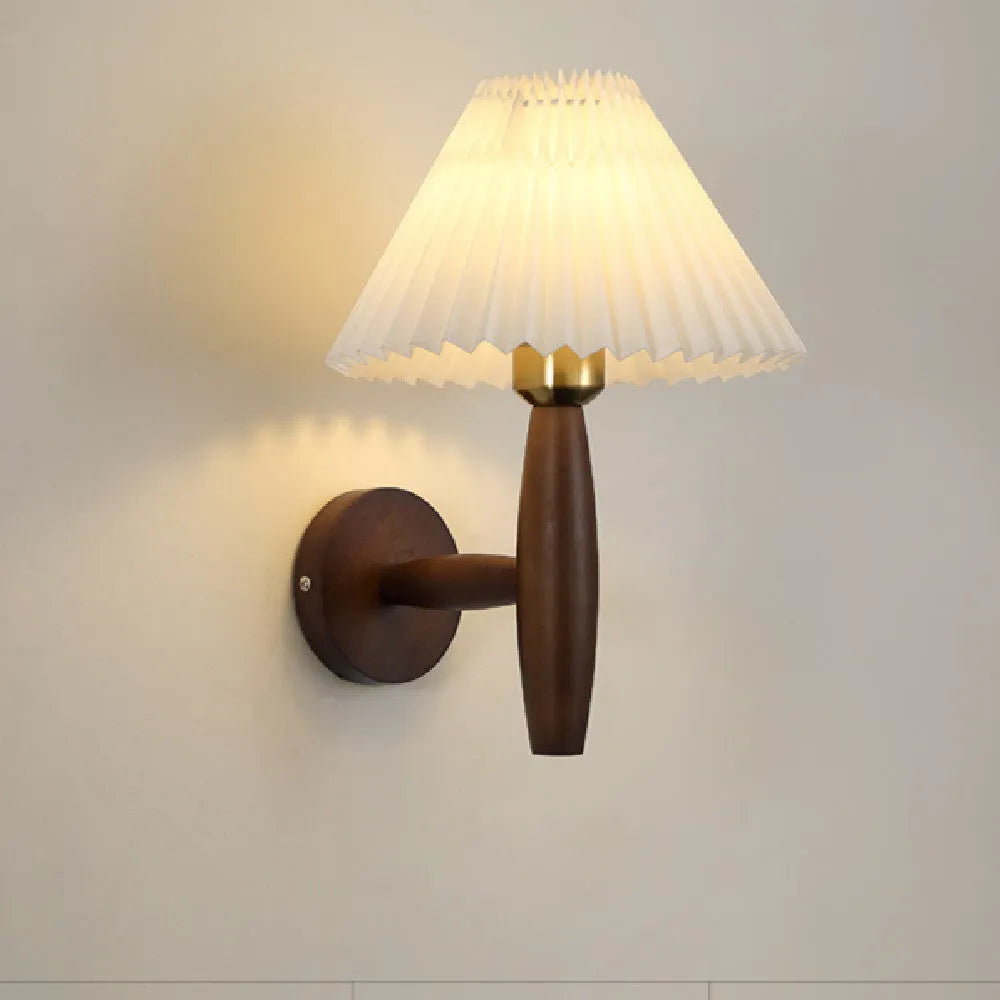 American retro rubber wood and fabric wall lamp in walnut finish on a wall.