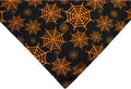 Reversible black and orange Halloween dog bandana with pumpkin and spider web patterns.