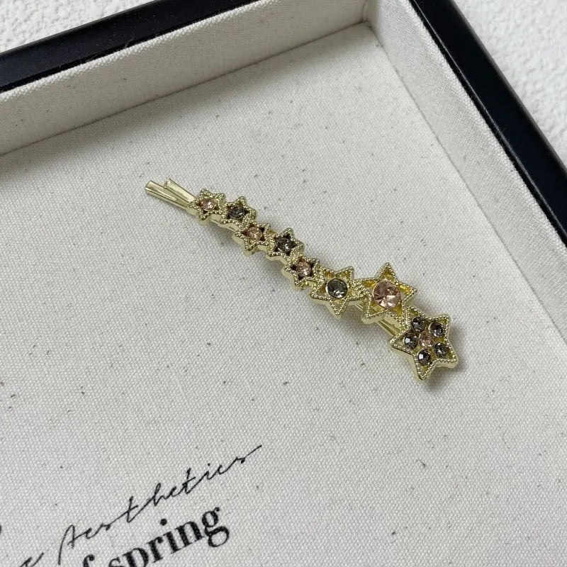 Korean style gold electroplated alloy hair barrette featuring a five-pointed star and word design.