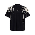 Black loose fit T-shirt with padded shoulders featuring decorative rivet detailing and ribbed texture