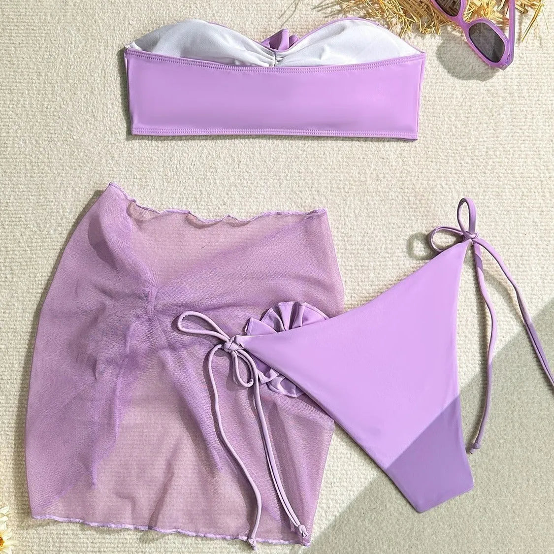 Women's pink swimsuit top with a large 3D flower tie and matching skirt set on a mannequin.