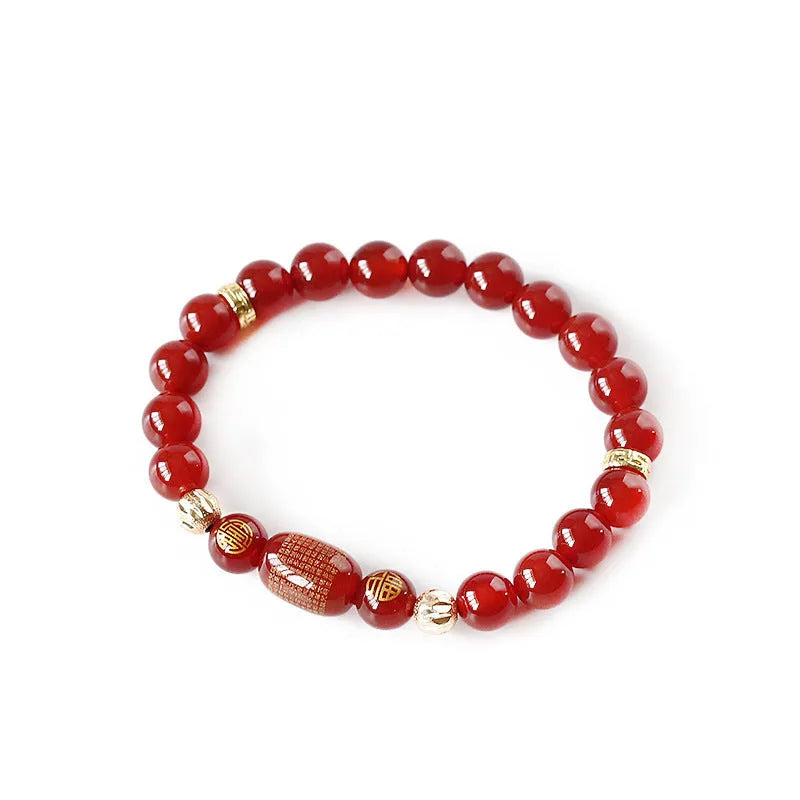 Close-up of a red agate Guanyin bracelet with detailed rosary bead edging on a wrist.