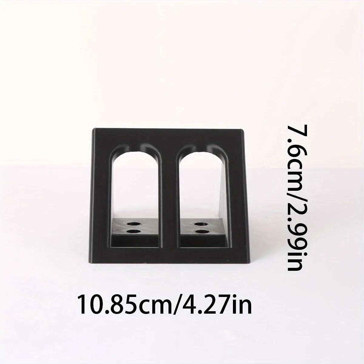 Matte black plastic pistol display stand with a punk-style design on a flat surface.