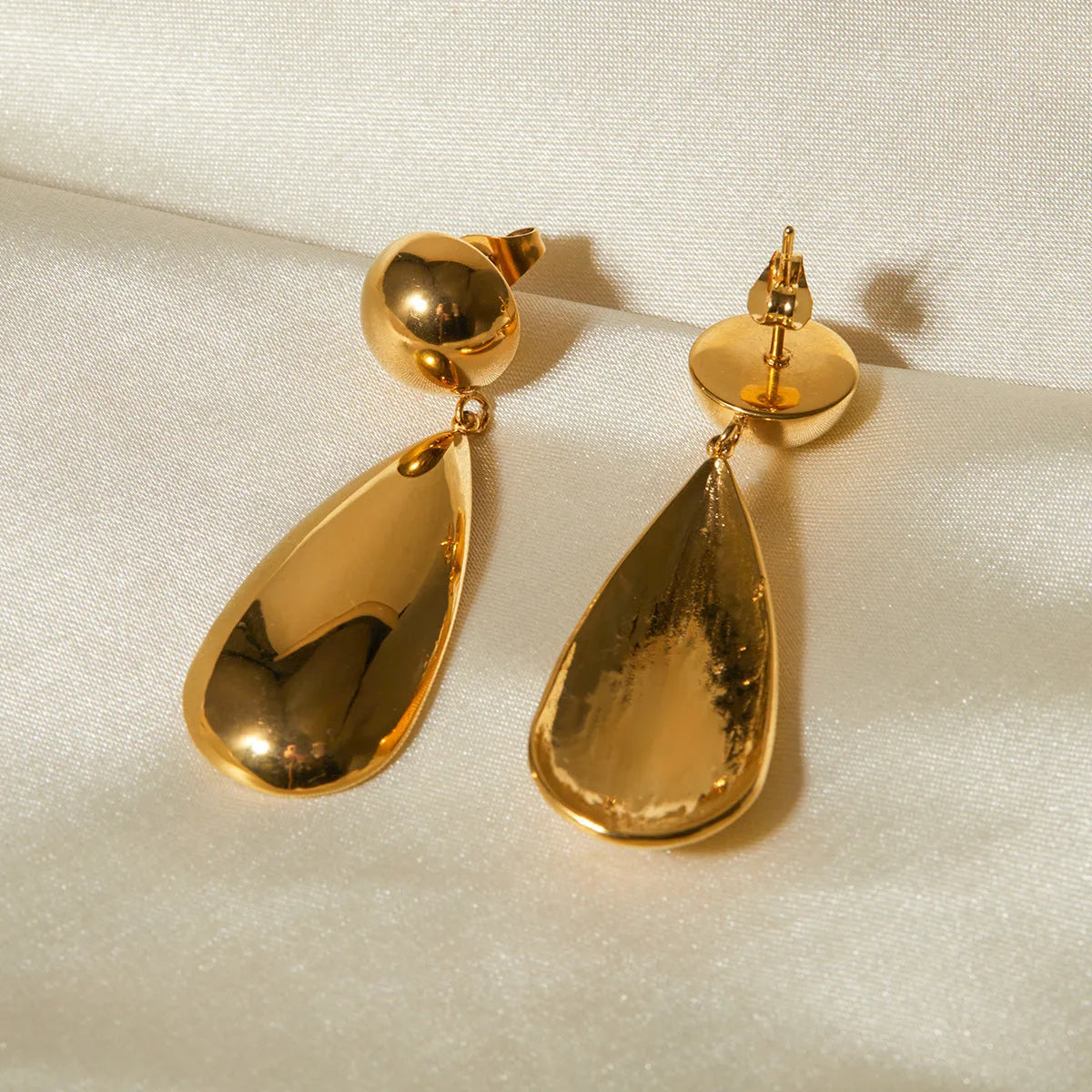Gold electroplated stainless steel earrings with geometric water droplet hemisphere pendant design