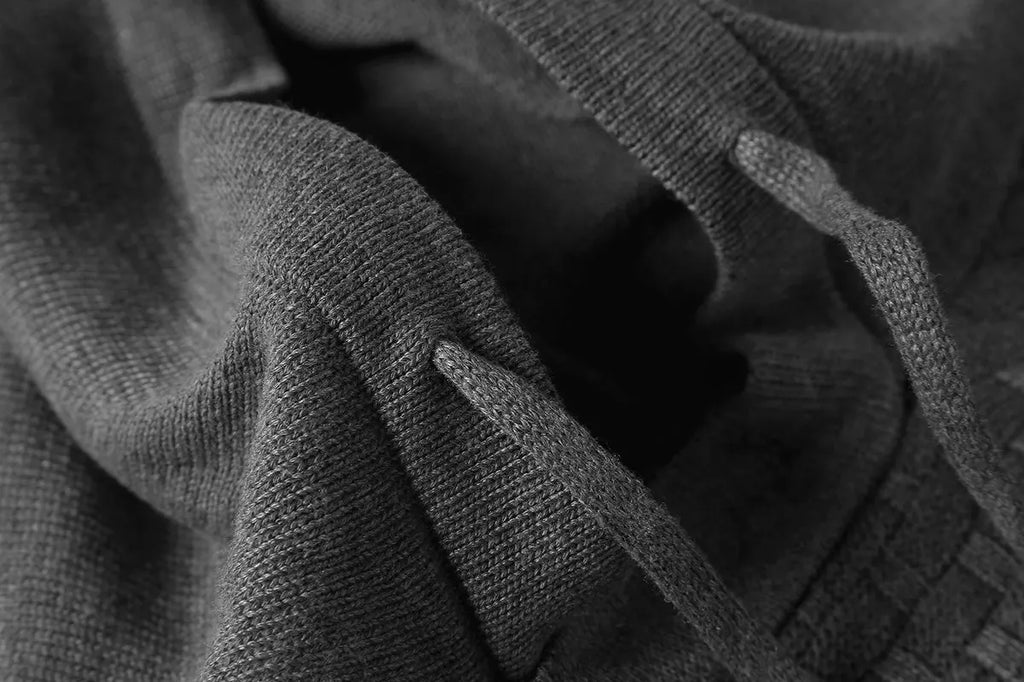 Men's black cotton-polyester hooded sweatshirt on a hanger, size label visible.