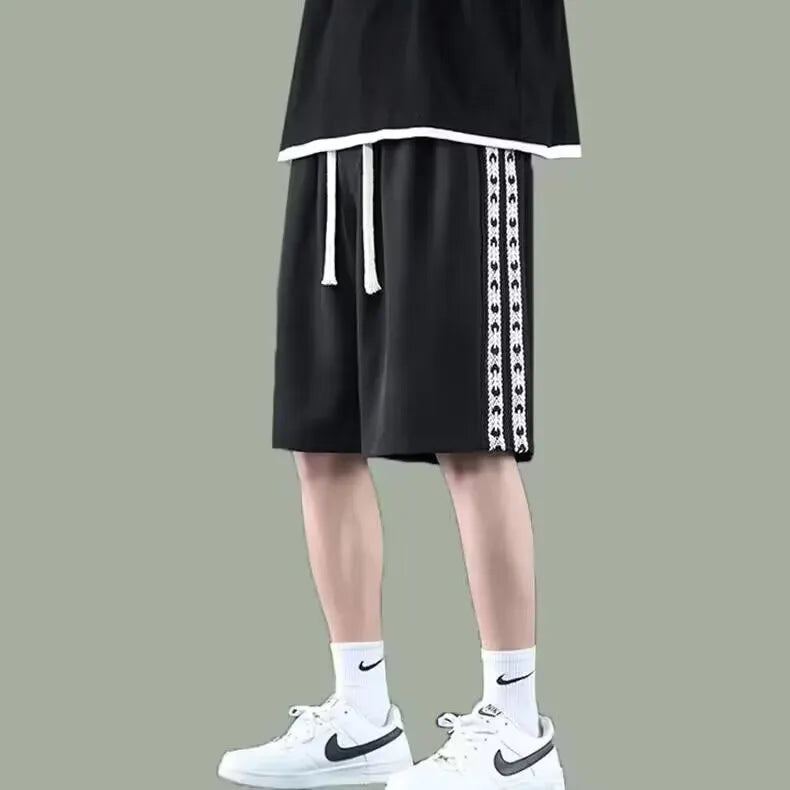 Men's loose-fit black track trousers with an elasticated waistband and baggy leg silhouette.