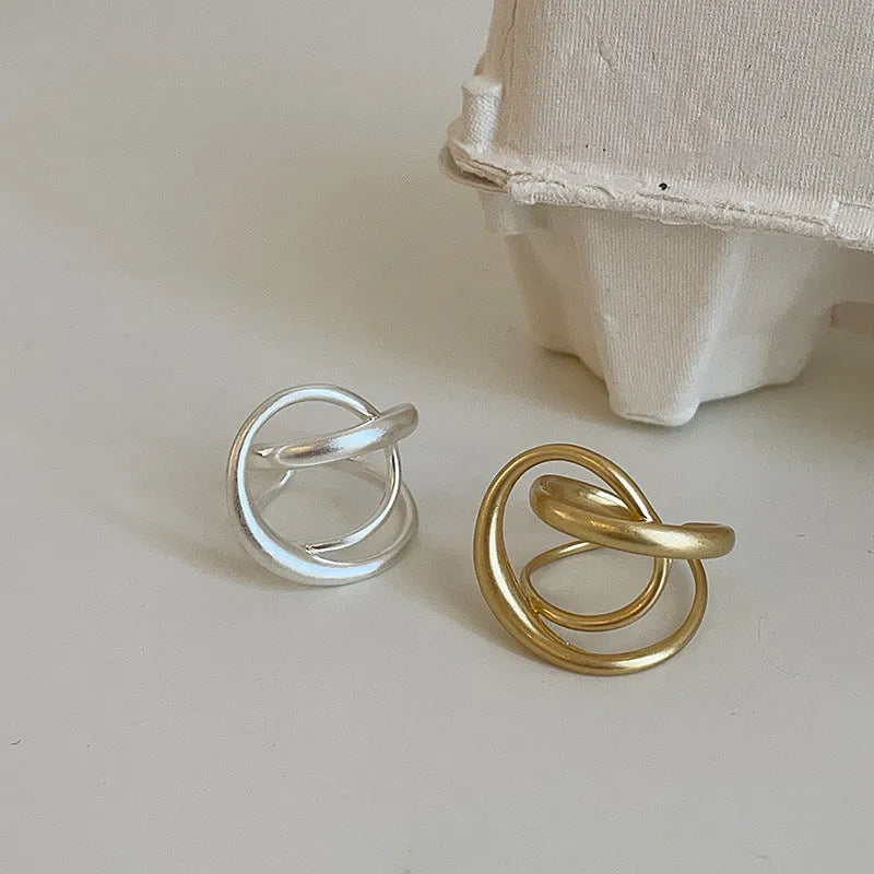 Gold and silver matte metal open rings with three-dimensional interlaced geometric design