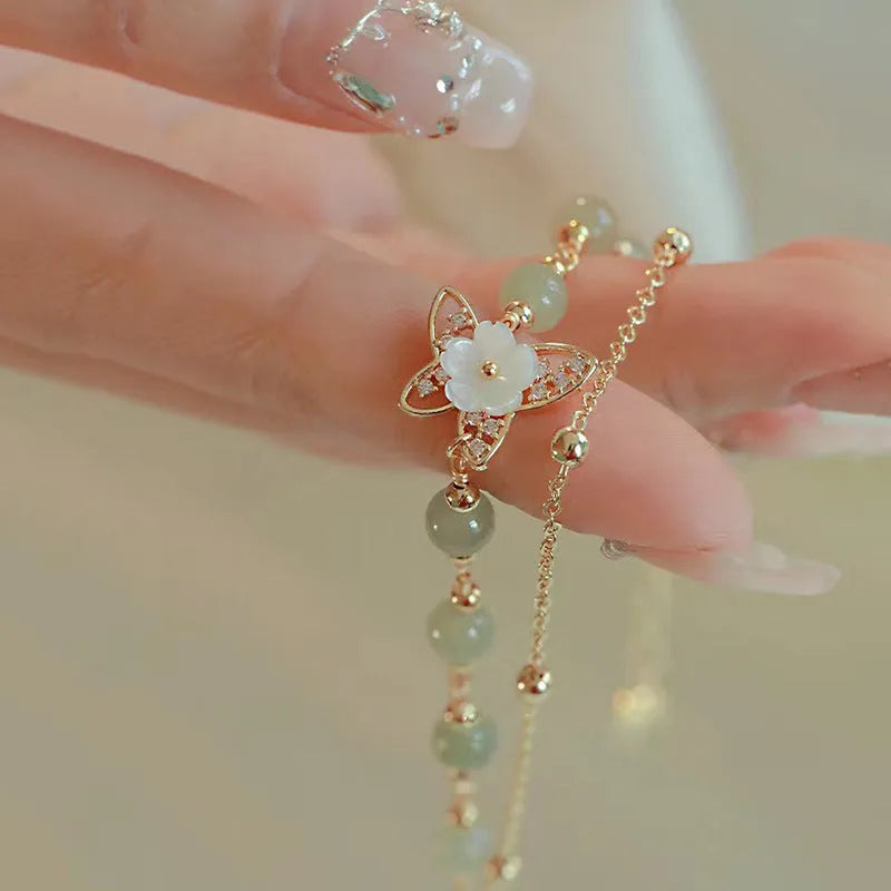 Yellow gold electroplated copper bracelet with genuine Hetian jade Bells of Ireland butterfly charm for women.