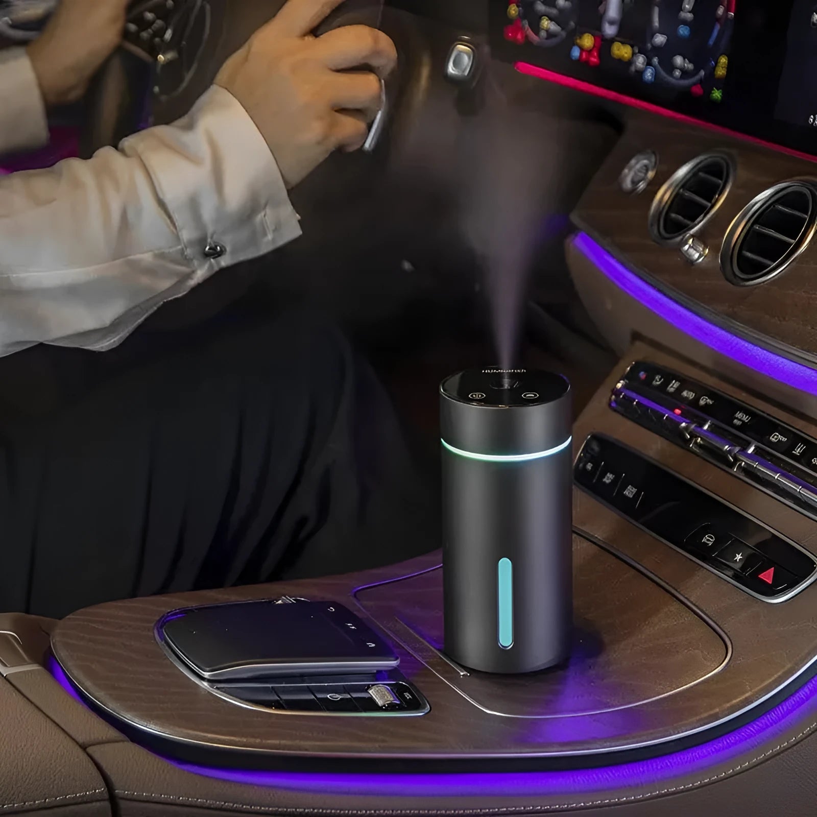 Black aluminium car humidifier diffuser with night light on a desk next to USB cable