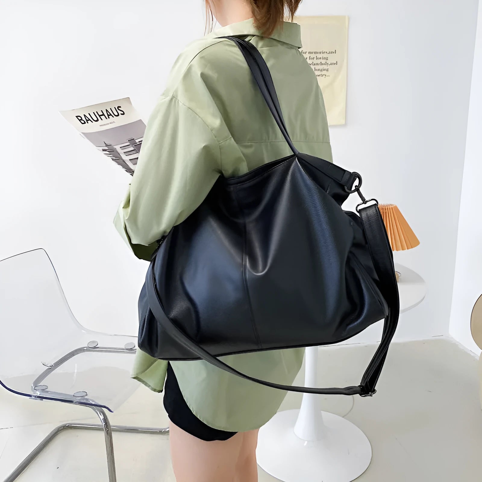 Large soft black PU messenger bag with car suture pattern, showing zip opening and adjustable shoulder strap.