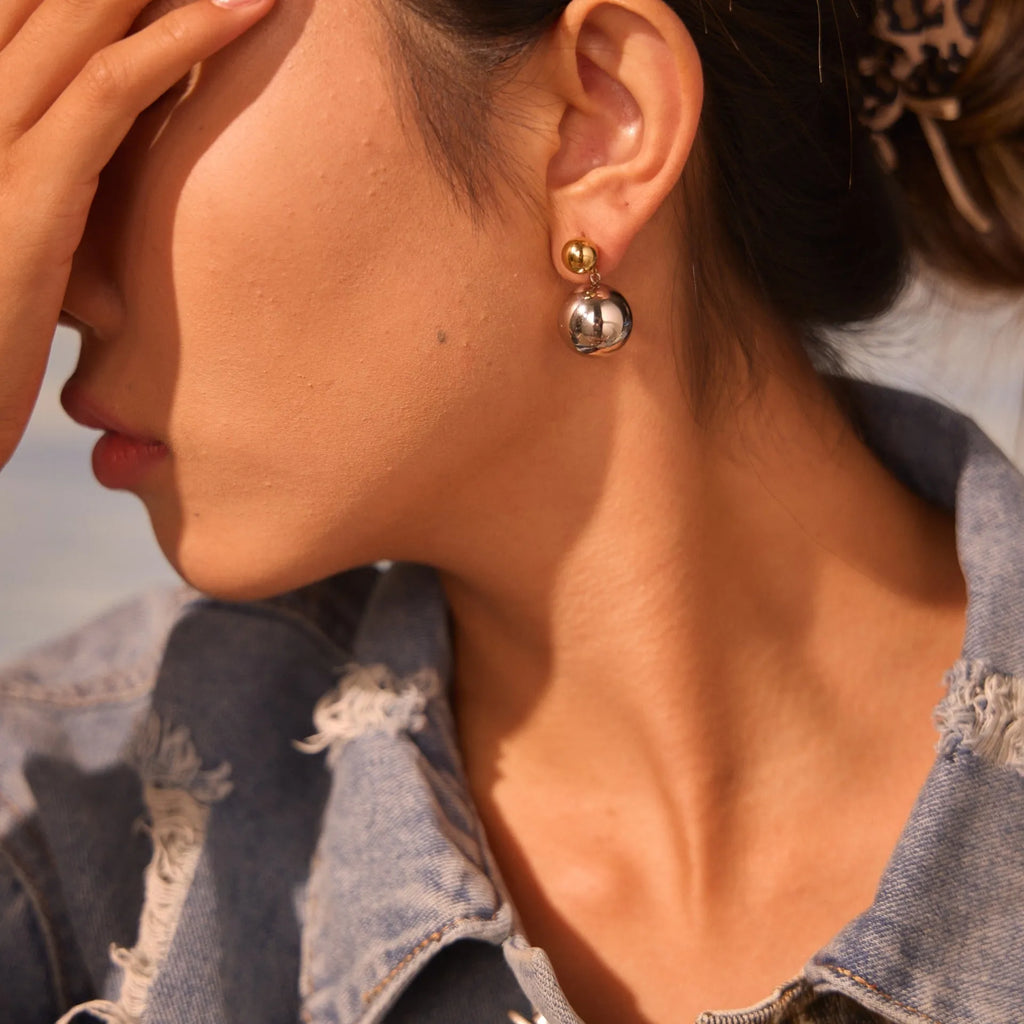 Stainless steel geometric ear studs with round beads and colour-block electroplated finish.