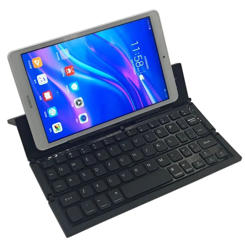 Black mini folding Bluetooth keyboard shown open next to a tablet, displaying its compact 5.8-inch size and aluminium bottom.