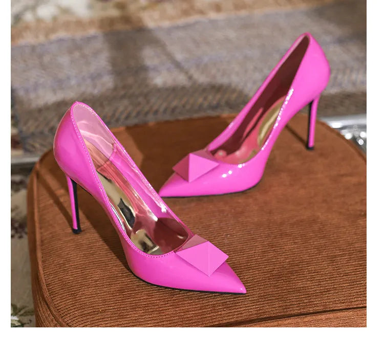 Pink patent leather women's stiletto heels with pointed toes and buckle fastening
