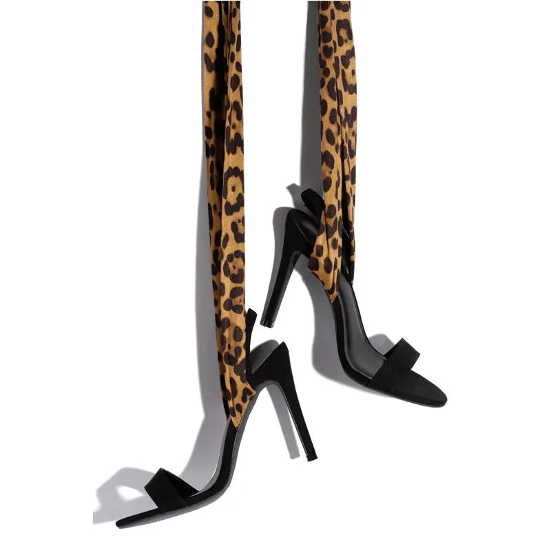 Light brown women's high heels with leopard print pattern and cross strap detail on the foot.