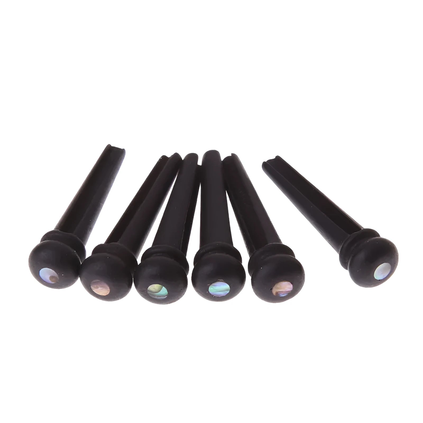 Six matt black ebony folk guitar string nails on a grey background