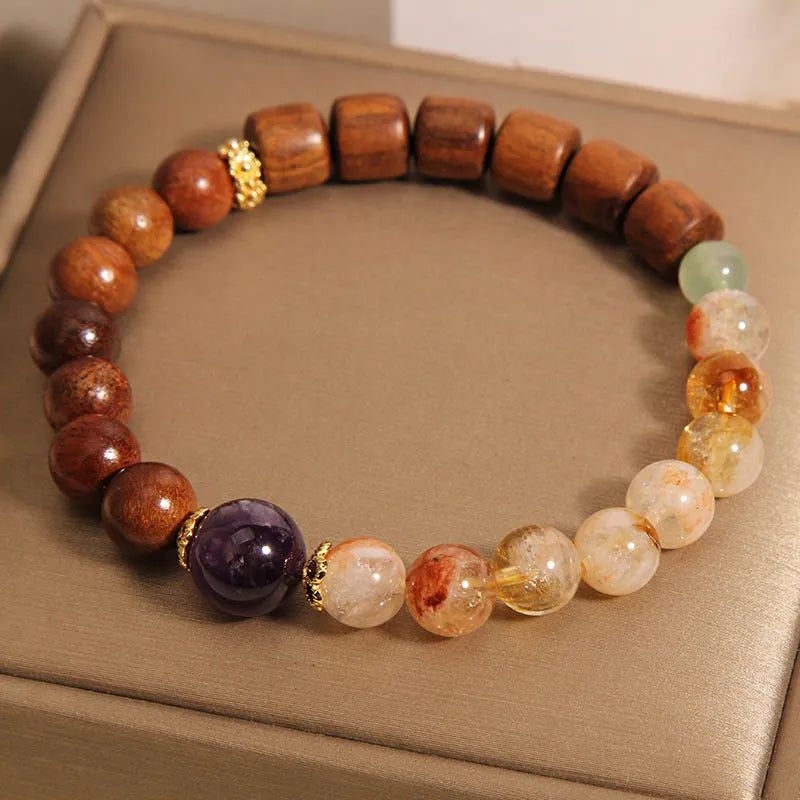 Yellow tower crystal, ebony, and amethyst bead bracelet with pearl and rhinestone details.