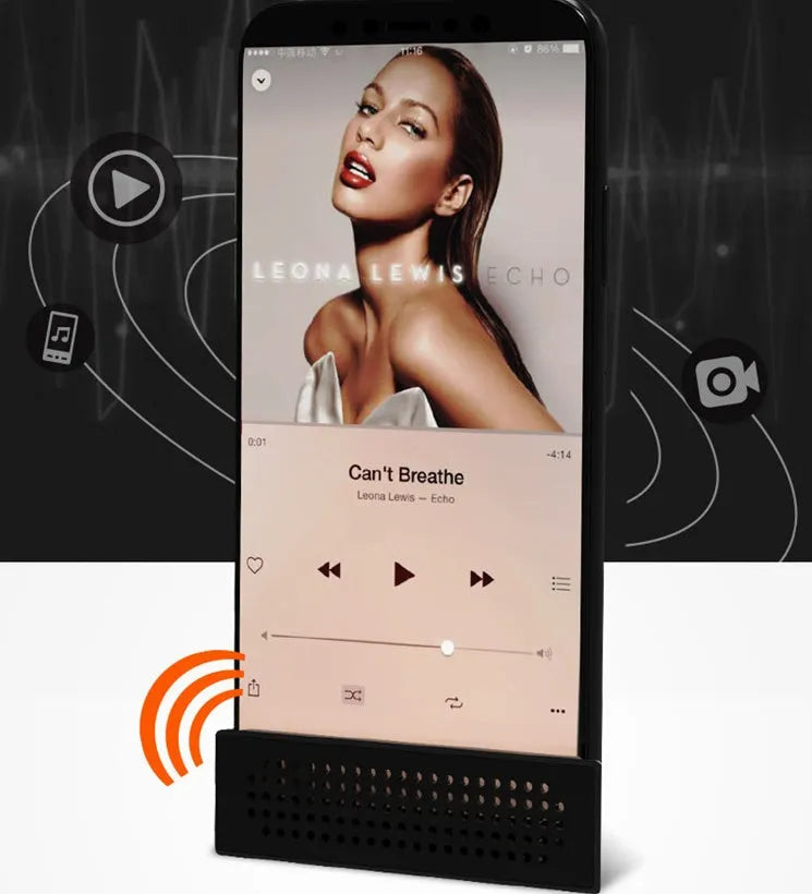 A small black plastic phone amplifier stand holding a smartphone on a desktop.