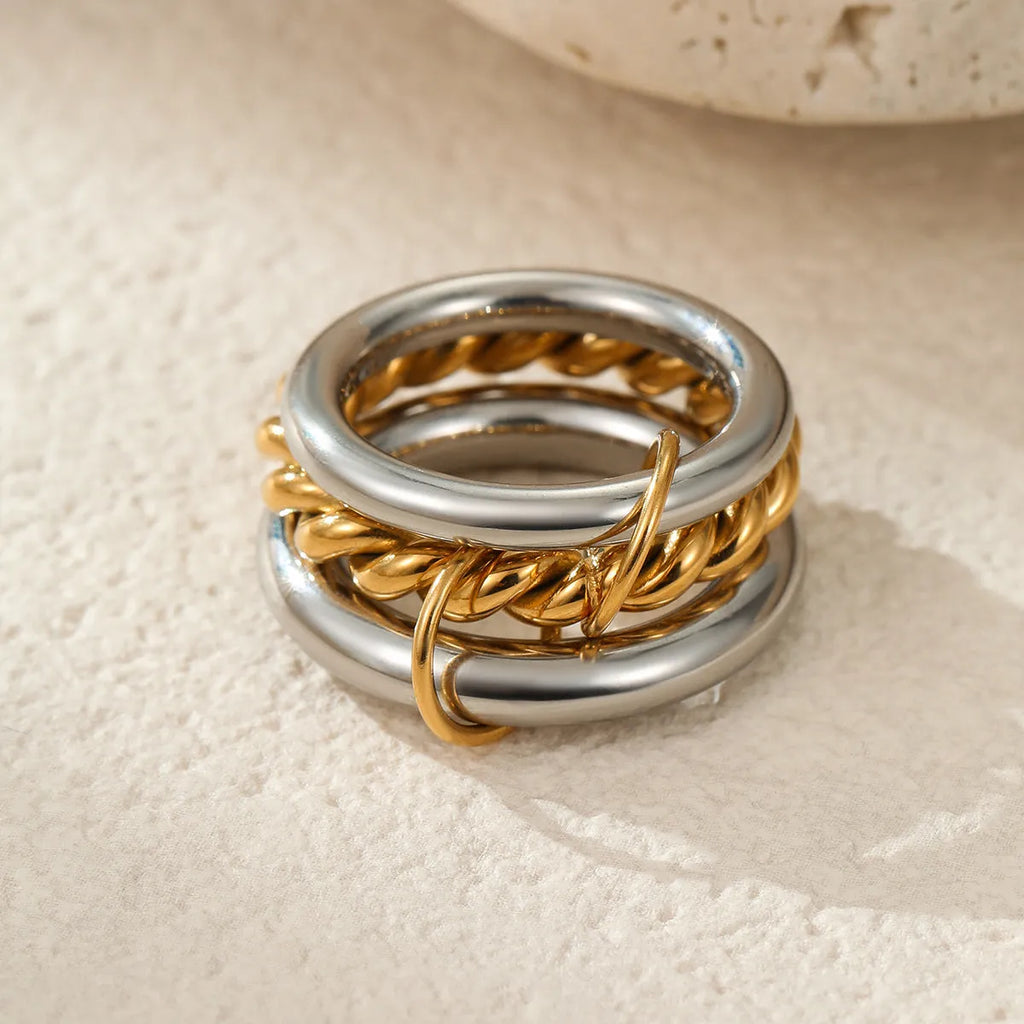 Stacked stainless steel rings with gold plating in coordinated colours showing layered hand jewellery design