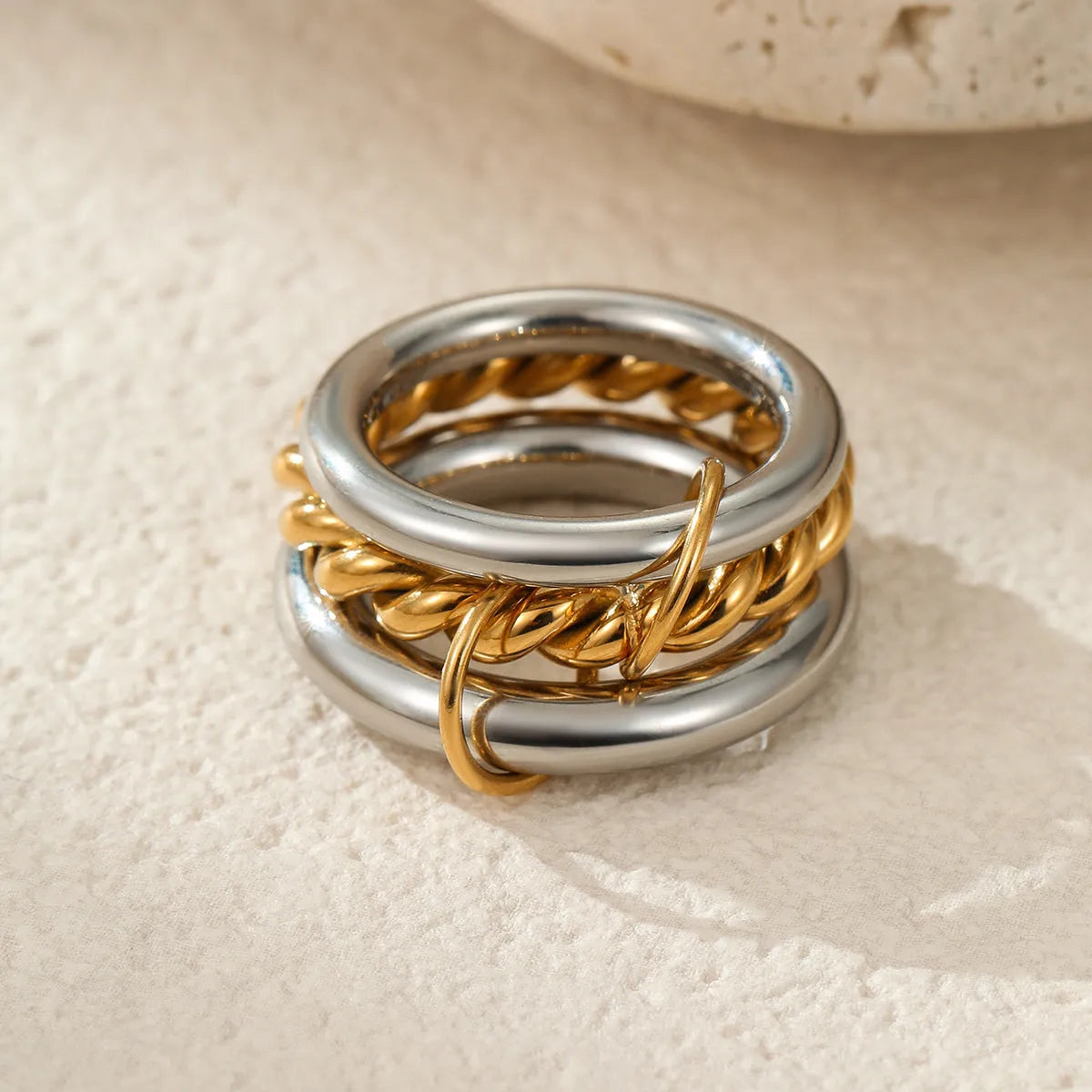 Stacked stainless steel rings with gold plating in coordinated colours showing layered hand jewellery design