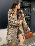 A model wearing a black faux fur mid-length coat with a large fur collar and front pockets.
