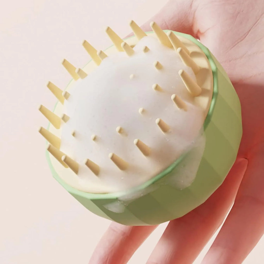 Green silicone double-sided pet bath massage brush with soft bristles on a bathroom counter.